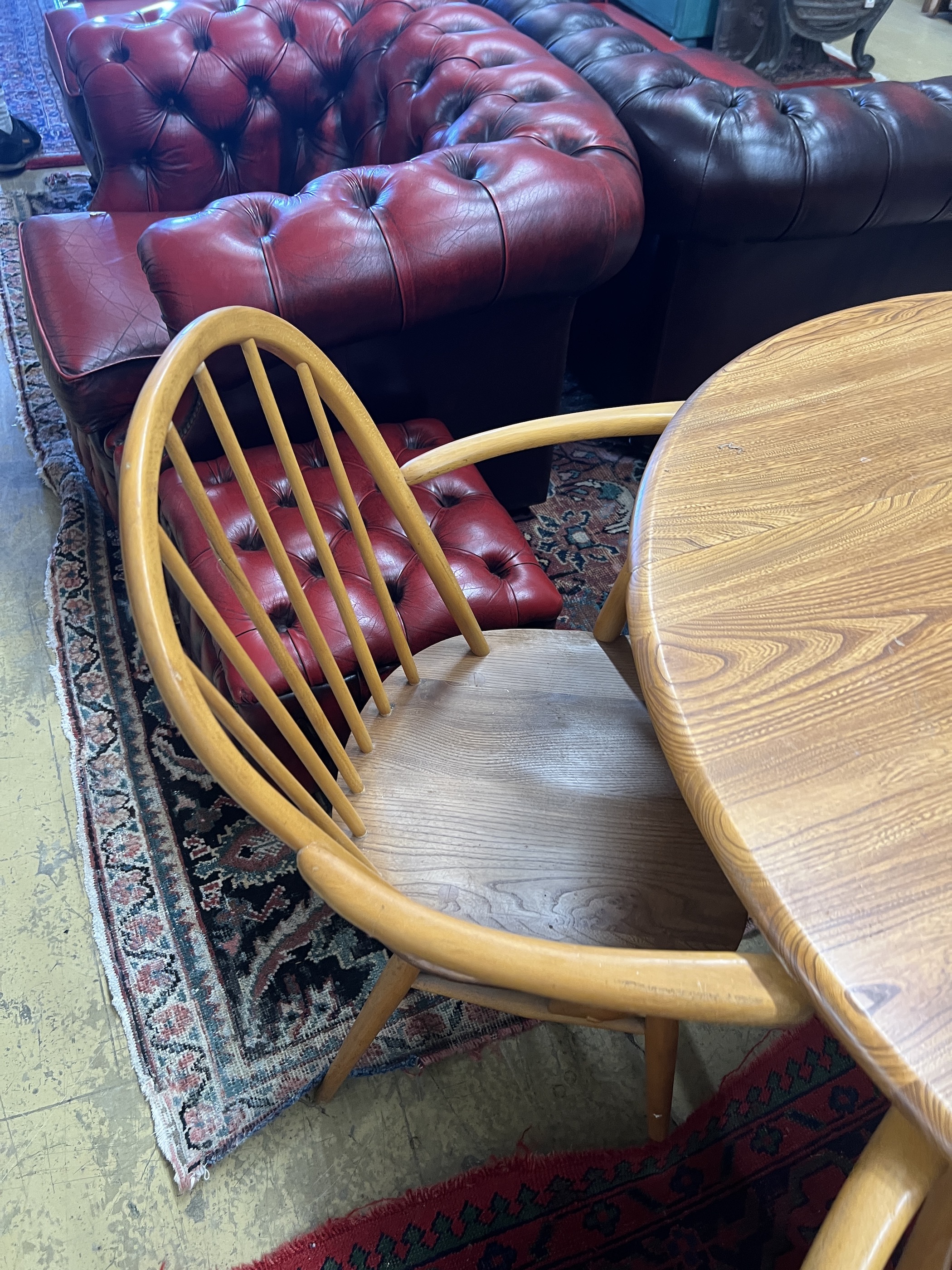An Ercol oval elm drop leaf dining table, length 123cm extended, width 113cm, height 71cm and four Ercol elm and beech elbow chairs